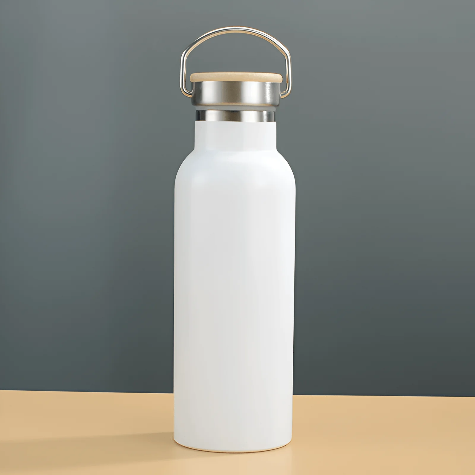 Minimalist insulated stainless steel water bottle with handle lid, reusable thermos bottle on a clean desk setup with books and picture frame in background.